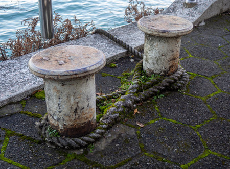 rope goes into the water from the bollard. Attaching boats to the pier. Port area. Sea port. stretched rope.の写真素材