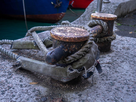 rope goes into the water from the bollard. Attaching boats to the pier. Port area. Sea port. stretched rope.の写真素材