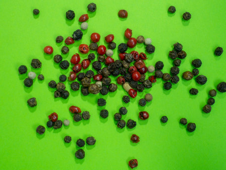 Peppercorns on a green background. Red, white and black peppercorns. The concept of natural cuisine. Seasoning for dishes. The concept of spicy food. Spicy condiment. Cooking. Asiaの写真素材