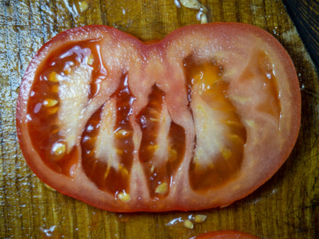 Sliced tomato on a cutting board. Circles of tomatoes. Vegetable snack close-up. Fresh ripe vegetable. Veganismの写真素材