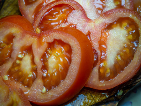 Sliced tomato on a cutting board. Circles of tomatoes. Vegetable snack close-up. Fresh ripe vegetable. Veganismの写真素材