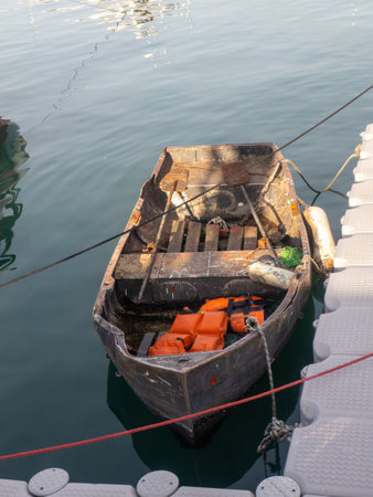 Port area. An old boat with life jackets in it. Vintage. The boat is tied to the pier. Batumiの写真素材