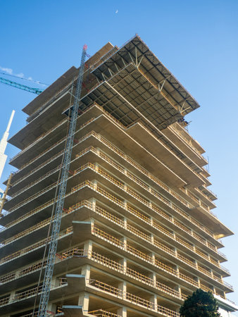 Construction of a high house. Down up. View from below. Frame of a concrete structure.  Platform at the construction site for receiving goodsの写真素材