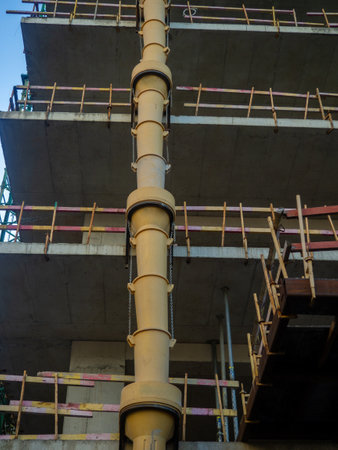Construction of a high house. Down up. View from below. Frame of a concrete structure. Sleeve for dumping debris at a construction siteの写真素材