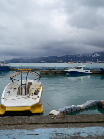 Ship at the pier. Winter season. Not a season. Lack of tourists. Ship repair concept. Shipyard. The yacht is afloat. Batumi port.Mainly cloudyの写真素材