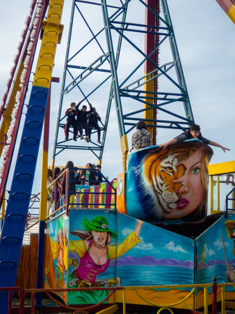 Batumi, Georgia. 03.11.2023  Children on a non-working carousel. Children's pranks. They occupied the carousel. Luna park. Winter at the resort. Not working. Part of the attraction. A place for children to relax. Adrenalin.のeditorial素材