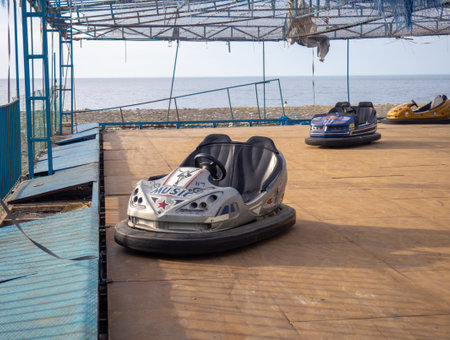 Batumi, Georgia. 03.11.2023 Abandoned Luna Park. Autodrom. Cars are covered with tarpaulins. Old carousels. Does not work. Broken attraction. resort in winter. Broken business. Emptiness. Not working entertainment.のeditorial素材