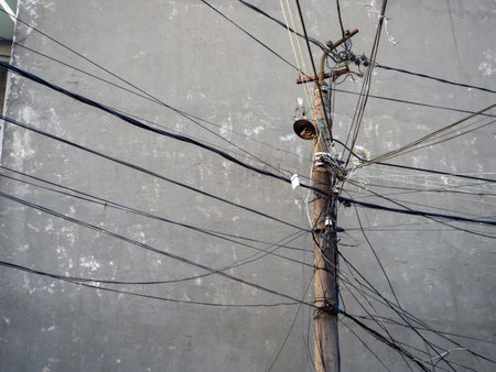 Power lines in an Asian village. Lots of wires on the pole. Electrification.Vintage technologyの写真素材
