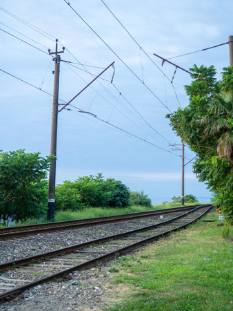 Railroad on the outskirts of the city. Road for electric transport among the trees. Sleepers and rails. Concept of path and destiny. wiresの写真素材