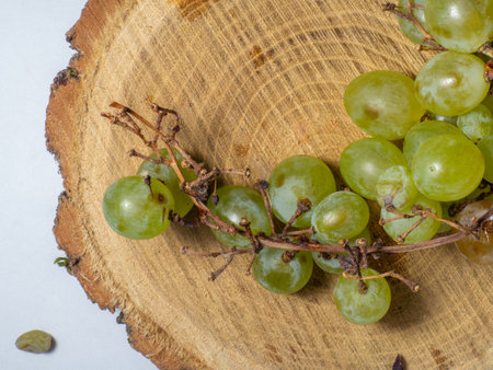 Grapes kishmish on a wooden background. The grapes are overripe. Harvest in the village. wine ingredientの写真素材