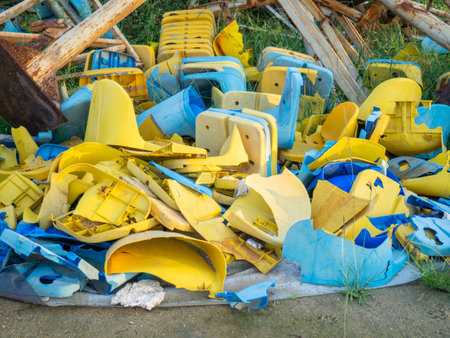 Old broken plastic chairs at the stadium. Fan riot concept. A pile of plastic chairs. Broken and abandoned. Yellow and blue chairsの写真素材
