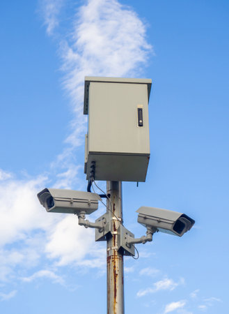 Street surveillance camera on a pole. Transformer panel. Against crime. Recording on a stationary camera. Fighting crime. Concept of issuing a fine. Traffic monitoring. Maintaining orderの写真素材
