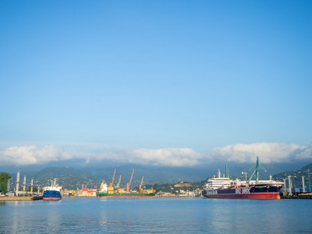 Batumi, Georgia. 09.22.2023 Landscape in the seaport. Port in the Caucasus. Ships and mountains. Clouds over the mountains. Port in Batumi. Logistics. Black Sea cargo transportation industryの写真素材