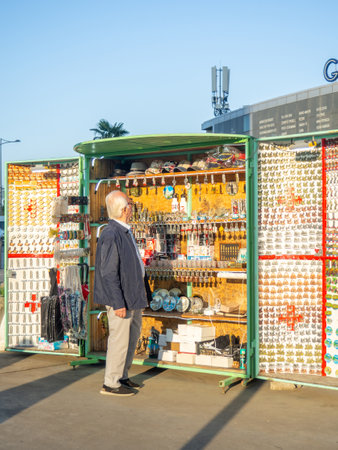 Batumi, Georgia.10.04.2023  Stall with souvenirs. Stall book. An elderly man chooses a souvenir. Magnets for memoryのeditorial素材