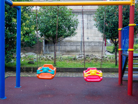 Plastic playground. Safe game for children. City infrastructure. Swings  made of plastic. Entertainment. Playground in the yard.の写真素材