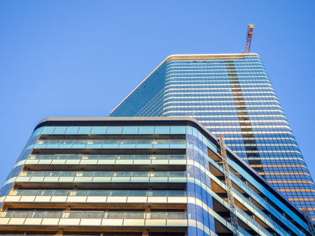 A newly built house. Glazed skyscraper. Reflection of the sky in the windows. Multi-apartment modern...