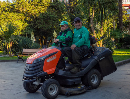 Batumi, Georgia. 10.12.2023 Workers on a lawn mower. Employees of the greenery farm in the park.のeditorial素材