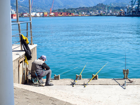 Batumi, Georgia. 10.14.2023 Fishermen in the port of Batumi. Waiting for a peck. People on vacation. Hobbies for people. Day off at the port. Fish catchersのeditorial素材