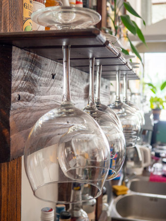 Glasses hang over the bar counter. The glasses are turned upside down. restaurant interior. Concept of drinking alcoholic beverages. Glass glasses for wine. Night club in daylightの写真素材