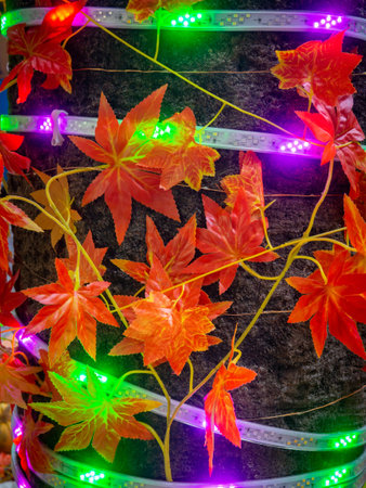 Autumn holidays background. Bright leaves and illumination. Halloween decorations on the street near the restaurant. Holiday decoration concept. Illuminations. Decoration of the restaurant veranda. .の写真素材
