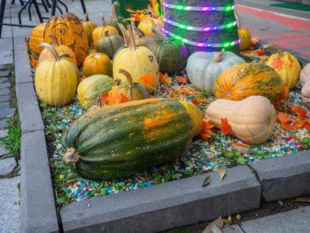 Decorations for Halloween on the street near the restaurant. Autumn holiday decorations. Illuminations. Restaurant patio decoration. Painted multi-colored pumpkins. All Saints' Day. The holiday is approaching. October 31. Preparationの写真素材