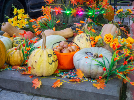 Decorations for Halloween on the street near the restaurant. Pumpkins are placed near the tree. Restaurant patio decoration. Painted multi-colored pumpkins. All Saints' Day. The holiday is approaching. October 31. Preparationの写真素材