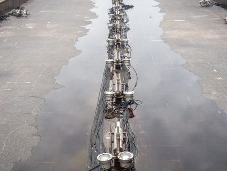 Empty fountain in a city park. Dehumidification. Cleaning the fountain with a hose. The device of the fountain. Pipes for water supply. Water hoses. Modern technologies. Infrastructure maintenance.の写真素材