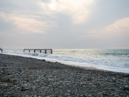 Destroyed pier under the waves. Bad weather at sea. Beautiful seashore with old architecture. Pier on the water in Batumiの写真素材