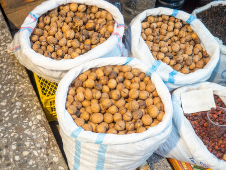 Oriental bazaar counter. Assortment on the market. Nuts at a market in Georgia. rose hip, walnutの写真素材