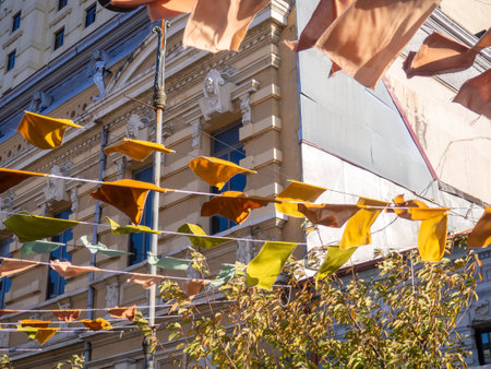 Flags over the street. City celebration concept. Warm colors. Scenery over the street. Festivalの写真素材