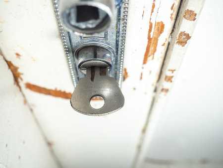 Part of an old door. White paint is coming off the wood. Surface with peeling paint. uneven. Old door handle. Concept of a key in a door.の写真素材