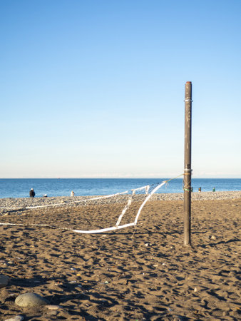 Fallen volleyball net on the beach. The concept of winter at the Black Sea resort. There is no game. The resort is out of season. Abandoned volleyball court.の写真素材