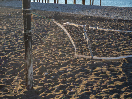Fallen volleyball net on the beach. The concept of winter at the Black Sea resort. There is no game. The resort is out of season. Abandoned volleyball court.の写真素材