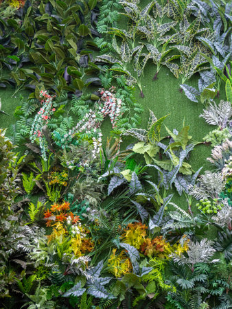 Background of artificial plants on the wall. exterior of the house is decorated with artificial flowers. House facade design. Green background. A bold design decision.の写真素材