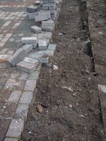Renovation of the pedestrian zone. Excavation. Laying tiles outdoors. Concrete tiles. Infrastructure repairの写真素材