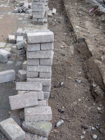 Renovation of the pedestrian zone. Excavation. Laying tiles outdoors. Concrete tiles. Infrastructure repairの写真素材