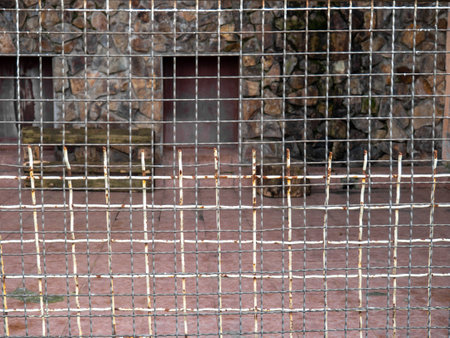 Outdoor fence at the zoo. Empty cages in the zoo. Winter at the zoo. The animals hid. Empty animal enclosure. Latticeの写真素材