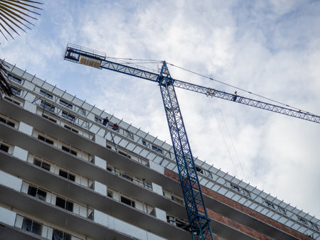 facade of an unfinished high-rise building. Construction crane near a panel house. Balconies of a building under construction.の写真素材