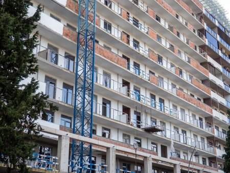 facade of an unfinished high-rise building. Construction crane near a panel house. Balconies of a building under construction.の写真素材