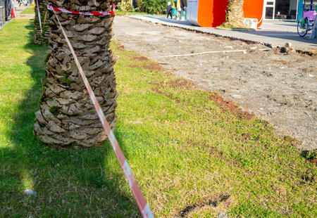 Repair work in the park. Fencing tape near the lawn. Fenced area. No entry. No passage conceptの写真素材