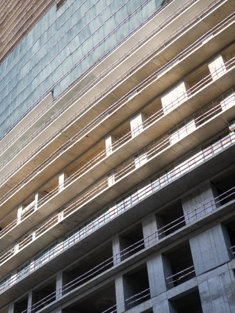 Concrete frame without facade. Unfinished construction of a multi-story building. Modern construction. Construction safety netsの写真素材