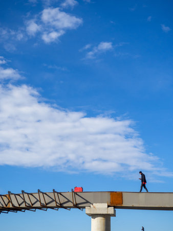Batumi, Georgia. 03.24.2024 A man stands alone on an overpass under construction. At construction...