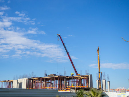 Builders at home construction. Construction site. Crane and construction of new floors
