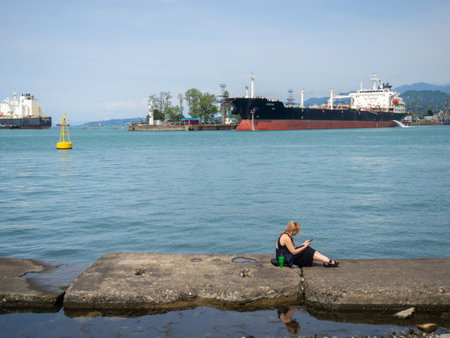 Batumi, Georgia. 05.10.2024 atmosphere of a seaport. Pier at the cargo port. People relax on the embankment. Batumi seaport.のeditorial素材