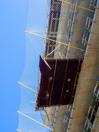 Rescue net on a house under construction. Construction of a multi-storey building. Housing industry. A place for people to settle. Modern architectureの写真素材