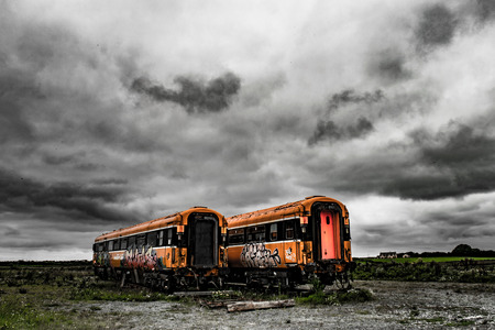 Abandoned train coaches in Ireland under a cloudy skyのeditorial素材