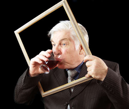 Businessman taking a quick drink breaking the frameの写真素材