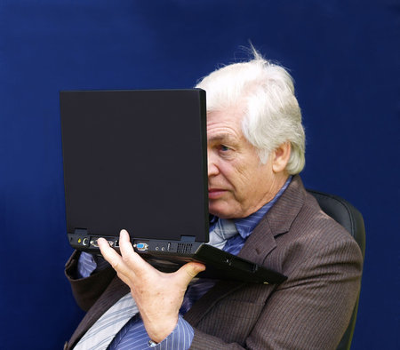 Senior executive  looking closely at his laptop      