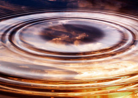 Sunset reflected in a pond with cloudsの写真素材