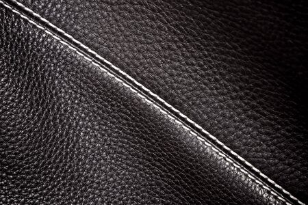 black leather background stitched up by white threadの写真素材